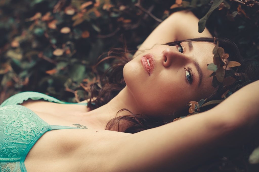 modelo silvia deitada entre as folhas no chão de um jardim