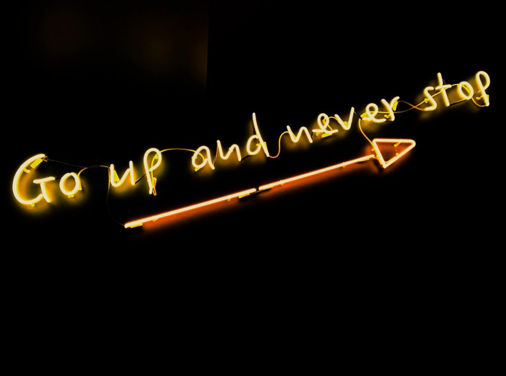 Escrito em neon amarelo: Go up and never stop